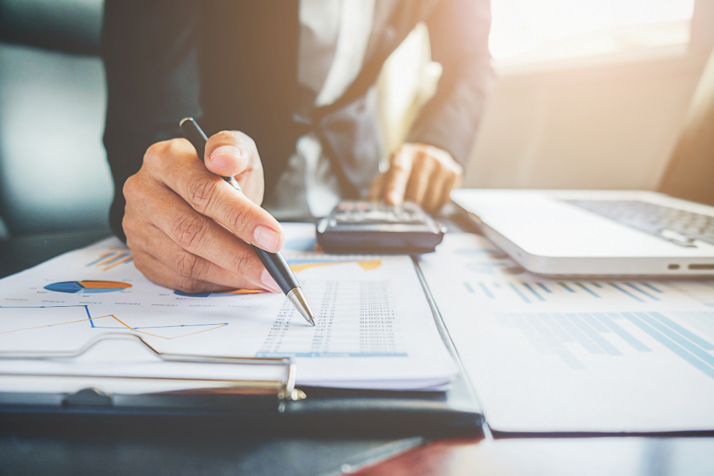 accountant making calculations on cooperation analyst chart